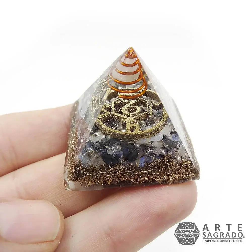 Mano sosteniendo la vista lateral de la Mini Pirámide Orgonita Capricornio con Piedra Luna y Hematita sobre fondo blanco