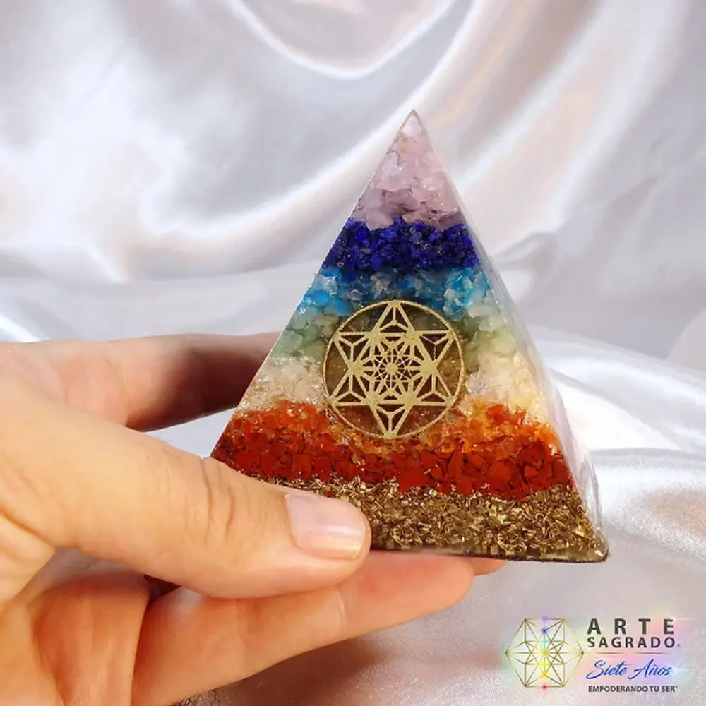 Mano sosteniendo la Pirámide Orgonita 7 Chakras sobre fondo blanco