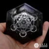 Mano sosteniendo el Amuleto reflejante Orgón de Arcángel Cubo de Metatrón con Shungita y Obsidiana Negra sobre fondo negro