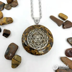 Vista frontal del Collar Mini Orgón Sri Yantra en Plata 0.925 con Ojo de Tigre con cadena de acero inoxidable acompañado de piedras de Ojo de Tigre sobre fondo blanco